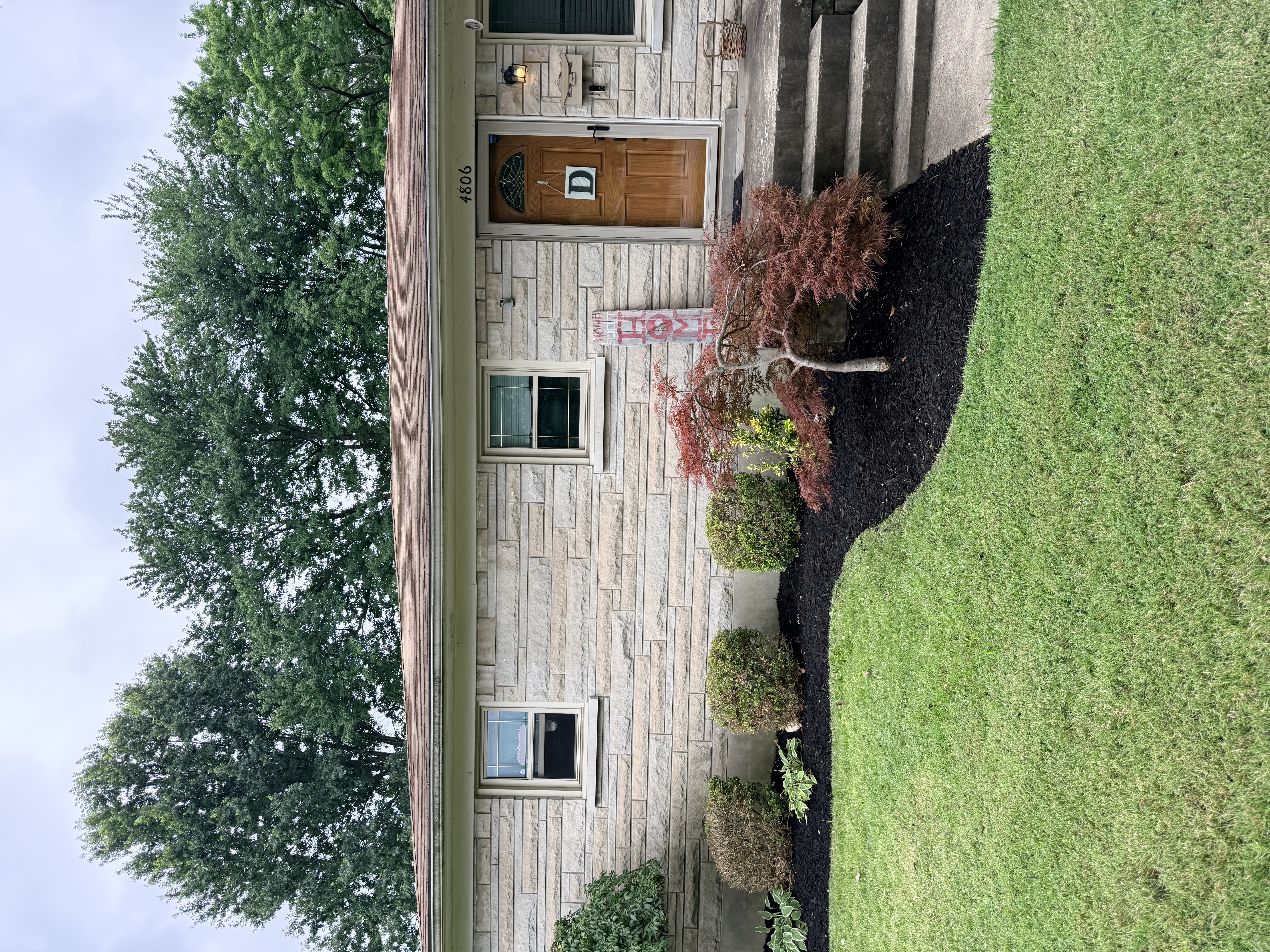 Entryway with fresh mulch bed and Japanese maple installed